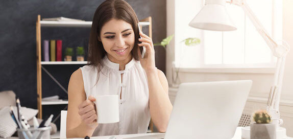 Woman having coffee while taling on the phone